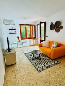 ein Wohnzimmer mit einem orangenen Sofa und einem Tisch in der Unterkunft Les cases del vent I in L'Ametlla de Mar
