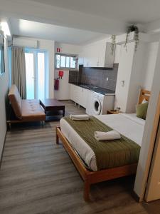 a bedroom with a large bed and a kitchen at LISABONNA GUEST HOUSE in Lisbon