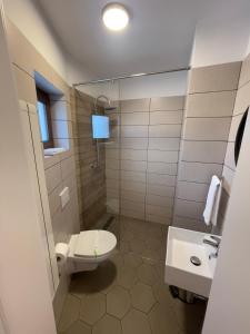 La salle de bains est pourvue de toilettes et d'un lavabo. dans l'établissement Rooms, à Bacău