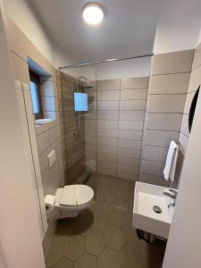 a bathroom with a toilet and a sink at Rooms in Bacău