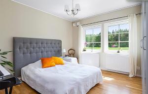 a bedroom with a large bed and a window at Cozy Home In Nykping With House Sea View in Oxelösund