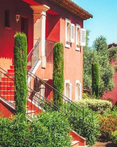 un edificio rojo con una escalera y algunos arbustos en Domaine de l'Astragale, en Saint-Tropez