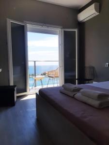 a bedroom with a bed and a view of the ocean at OLYMPIADA View 1 in Pythagoreio
