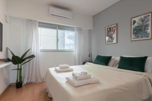 a white bedroom with two towels on a bed at Gregoria Perez 3500 'b' - 1 Bd In Colegiales in Buenos Aires