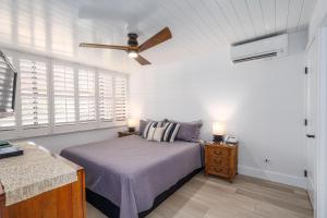 a bedroom with a bed and a ceiling fan at Kamaole Sands 1-305 in Wailea +40 photos