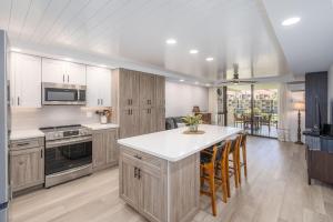 a kitchen with wooden cabinets and a kitchen island at Kamaole Sands 1-305 in Wailea