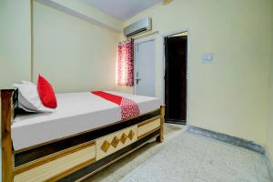 Un dormitorio con una cama con almohadas rojas. en OYO Flagship Hotel Sweet And Soul, en Jamshedpur