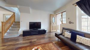 a living room with a couch and a flat screen tv at Charming 5 bedroom house in Grays in Grays Thurrock