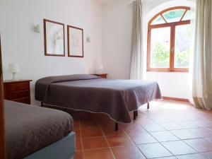 1 dormitorio con 2 camas y ventana en I Fiori di Salici, en Capoliveri