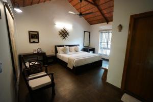 a bedroom with a bed and a chair in a room at Brown Town Resort & Spa in Hyderabad
