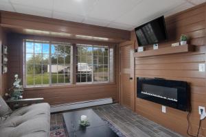 sala de estar con chimenea y TV de pantalla plana en 1BR Fife Lake Haven with Fire Pit & Hot Tub en Fife Lake