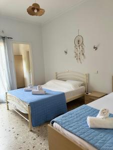 a bedroom with two beds and a chandelier at Santa Marina Rooms in Agia Marina Aegina