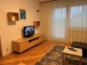 a living room with a television on a wooden cabinet at Apartment LAGUNA 37 in Izola