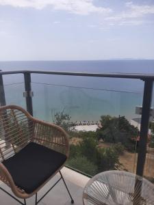 una silla y una mesa en el balcón con vistas a la playa en OLYMPIADA View 1, en Pythagoreio