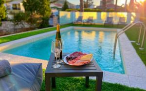 a table with a plate of food and a bottle of wine at Gournes Mare Luxury Villa with private pool in Gournes