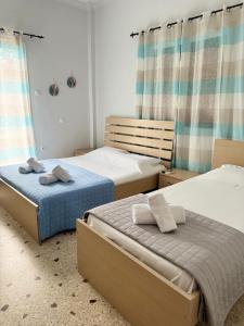 a bedroom with two beds with towels on them at Santa Marina Rooms in Agia Marina Aegina