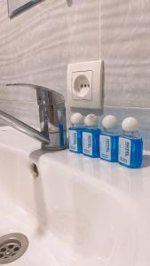 un lavandino in bagno con rubinetto e una fila di bottiglie blu di Registan Family Hotel a Samarkand