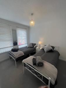 a living room with two beds and a couch at No 6, Ayr, 140m2, New Decor 2024, 3bedroom, detached house, with private gardens in Ayr