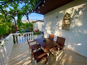 een patio met een houten tafel en stoelen op een balkon bij Apartment Ambretta in Savudrija