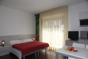 a bedroom with a red bed and a television at Hotel Luciana in Bibione