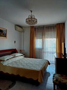 a bedroom with a large bed and a chandelier at Tina'home in Selcetta