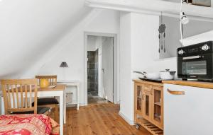 cocina con mesa y microondas en Cozy Home In Haderslev With Kitchen, en Haderslev