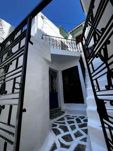 a white building with a black door and stairs at Aelia in Ioulis
