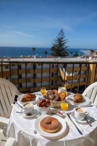 stół z jedzeniem i widokiem na ocean w obiekcie Los Ficus w mieście Playa del Ingles