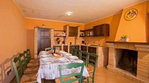 comedor con mesa con sillas verdes y chimenea en Casolare Abruzzese : natura, incanto e mindfulness, en Carunchio