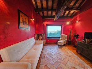 sala de estar con sofá y pared roja en Casolare Abruzzese : natura, incanto e mindfulness, en Carunchio