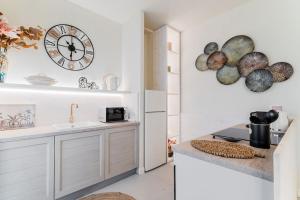 a kitchen with a sink and a clock on the wall at Petite Suite Vittoria - Brescia City - by Host4U in Brescia +15 photos