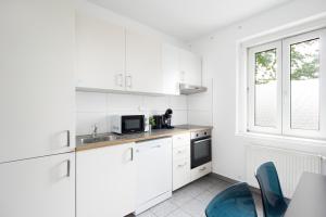 cocina blanca con fregadero y microondas en Apartment Kröllgasse I contactless check-in en Viena