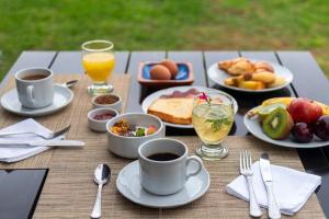 a table topped with plates of food and cups of coffee at Patios de Cafayate - Wine Hotel & Restaurant in Cafayate