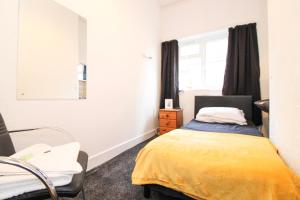a bedroom with a bed and a chair and a window at Pebbles guest house room 15 in Southampton
