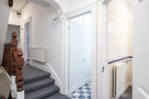 a hallway with a staircase with a white door at Pebbles guest house room 15 in Southampton