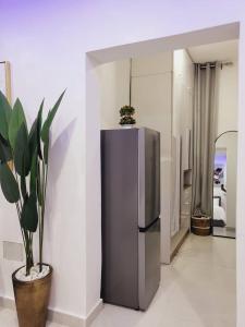 a kitchen with a stainless steel refrigerator and a potted plant at Stylish Modern Studio Apartment Banana Island Ikoyi in Lagos