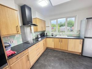 a kitchen with wooden cabinets and a stainless steel refrigerator at Golden Villa in Uxbridge