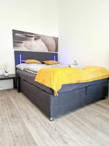 ein Schlafzimmer mit einem Bett mit einer gelben Decke darauf in der Unterkunft RPStay in Wien