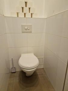 ein weißes WC im Bad mit weißen Fliesen in der Unterkunft RPStay in Wien