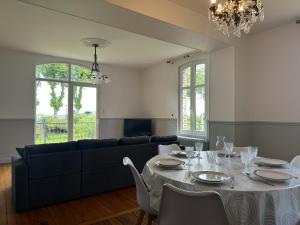 een woonkamer met een tafel en een bank bij Grande demeure face à la Baie de Somme, accès Quai in Saint-Valery-sur-Somme