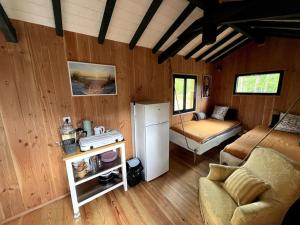 a room with a refrigerator and a couch in a room at Camping la Kahute - Tiny House au coeur de la fôret in Carcans