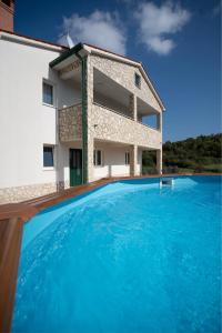 a villa with a swimming pool in front of a building at Holiday Home Veronica in Labin