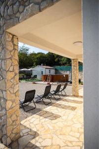 a patio with four chairs and a stone wall at Holiday Home Veronica in Labin