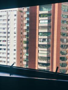 un edificio alto con plantas en sus balcones en Apartamento aconchegante nos Jardins., en São Paulo