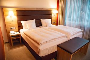 um quarto de hotel com uma cama grande e uma janela grande em Hotel Panorama em Einbeck