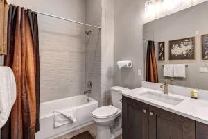 a bathroom with a toilet and a tub and a sink at Mayflower Lakeside 303-14 by Moose Management in Cranmer