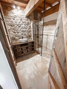 ein Badezimmer mit einem Waschbecken und einer Steinmauer in der Unterkunft Le Clos Bohème - Baron in Baron