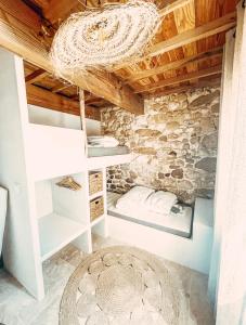 ein Schlafzimmer in einem Steinhaus mit einem Kronleuchter in der Unterkunft Le Clos Bohème - Baron in Baron