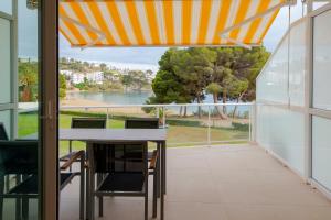 a balcony with a table and chairs and a view of the water at Apartamento Almadraba in Roses