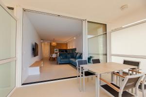 a dining room and living room with a large glass window at Apartamento Almadraba in Roses